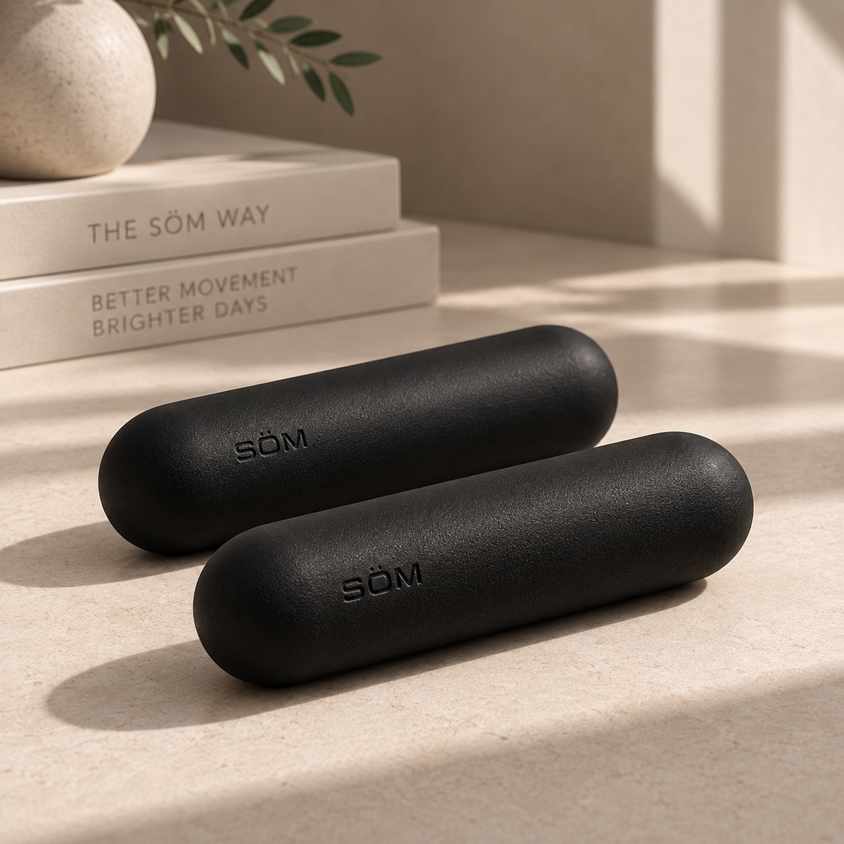 Pair of black SÖM Balance Weights in a minimalist studio setting