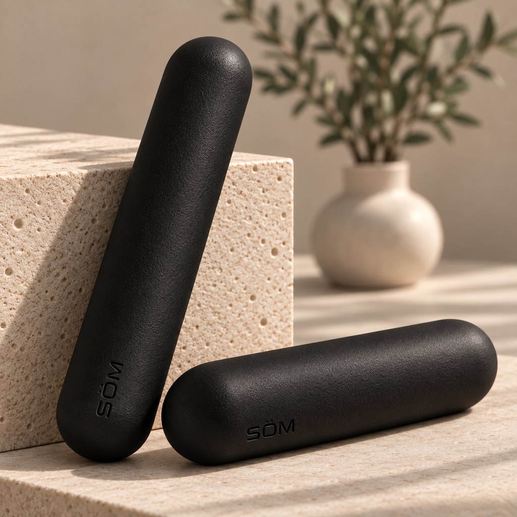 Pair of black SÖM Balance Weights displayed against a stone block