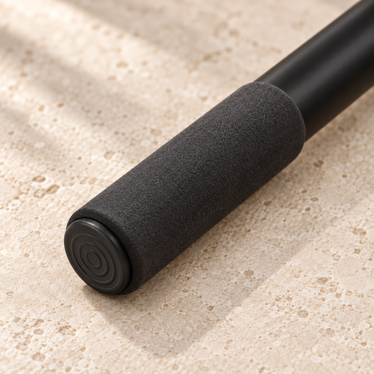 Close-up of the SÖM Mobility Stick’s textured foam grip and flat circular end cap.