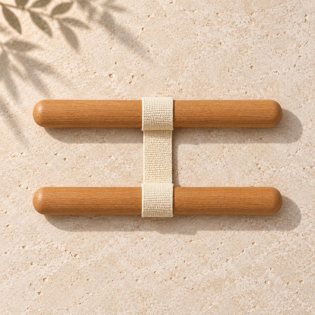 Overhead view of the SÖM Stretch System with two wooden bars connected by a cream woven strap.